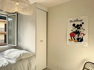 a bedroom with a mickey mouse poster on the wall at Appartement vue sur les toits de Propriano in Propriano