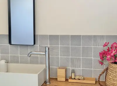 a bathroom with a sink and a vase of flowers at Appartement vue sur les toits de Propriano in Propriano