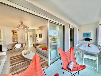 a living room with red chairs and a table at Appartement vue sur les toits de Propriano in Propriano
