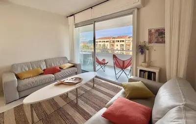 a living room with a couch and a table at Appartement vue sur les toits de Propriano in Propriano