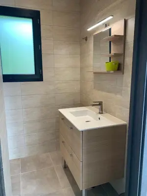 a bathroom with a white sink and a window at Villa SOLEIL in Figari