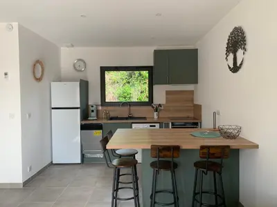 a kitchen with a counter and stools in it at Villa SOLEIL in Figari