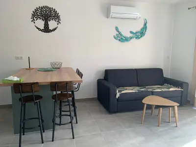 a living room with a couch and a table at Villa SOLEIL in Figari