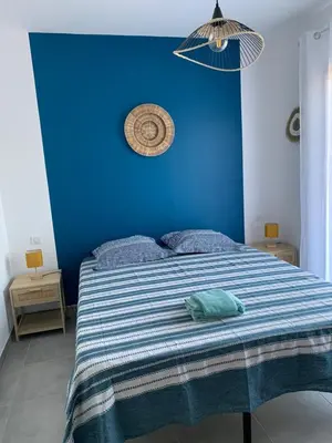a blue bedroom with a bed with a blue wall at Villa des Chênes in Figari