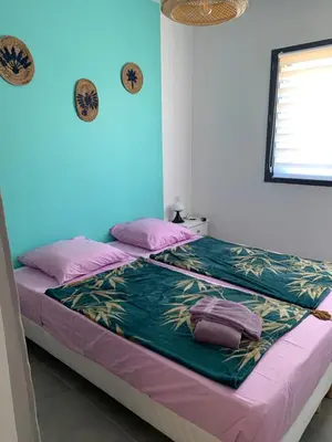 a bedroom with a bed with purple and green sheets at Villa des Chênes in Figari