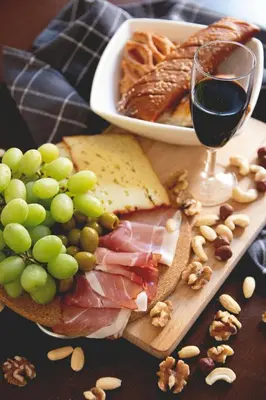 a plate of food with a glass of wine and grapes at Villa des Chênes in Figari