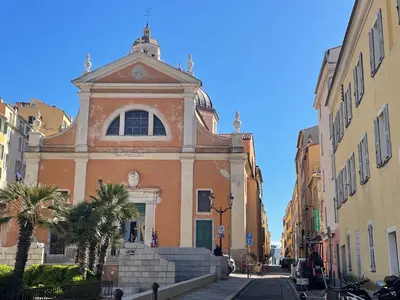 a building with a tower on a street at Appartement Marinella route des Sanguinaires Corse in Ajaccio