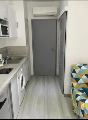 a small kitchen with a washing machine and a door at studio centre ville in Ajaccio