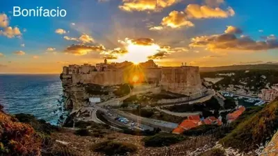 a view of a castle on a cliff with the sunset at Pépite du Maquis in Porto-Vecchio
