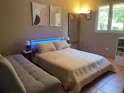 a bedroom with a bed and a couch in it at Pépite du Maquis in Porto-Vecchio