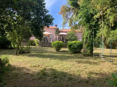 a house with a yard with trees and a swing at Pépite du Maquis in Porto-Vecchio