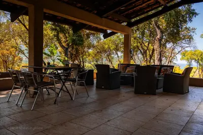 a patio with a table and chairs and trees at Domaine de la Testa in Sainte-Lucie de Porto-Vecchio