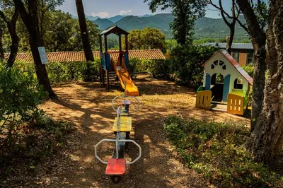 a playground with a slide and a play house at Domaine de la Testa in Sainte-Lucie de Porto-Vecchio