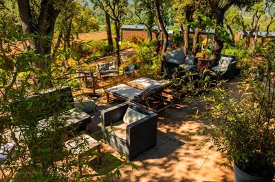 a yard with chairs and tables and trees at Domaine de la Testa in Sainte-Lucie de Porto-Vecchio