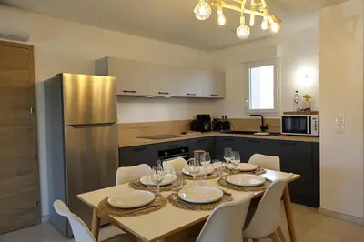 a kitchen with a table with wine glasses on it at I Tramizzi - Maison 3 Chambres à Bonifacio in Bonifacio