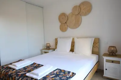 a bedroom with two beds and two mirrors on the wall at I Tramizzi - Maison 3 Chambres à Bonifacio in Bonifacio