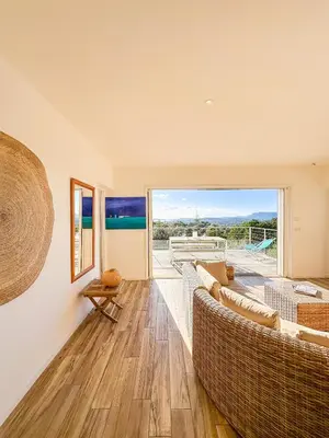 a living room with two couches and a view of the ocean at Casa Luna Di Santa Lucia in Sainte-Lucie de Porto-Vecchio