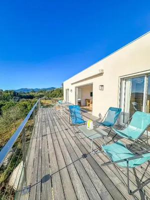 a deck with chairs and a table on it at Casa Luna Di Santa Lucia in Sainte-Lucie de Porto-Vecchio