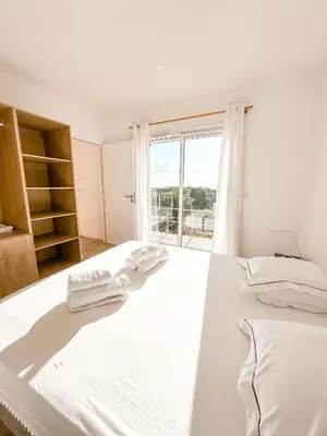 a bedroom with a large white bed with towels on it at Casa Luna Di Santa Lucia in Sainte-Lucie de Porto-Vecchio