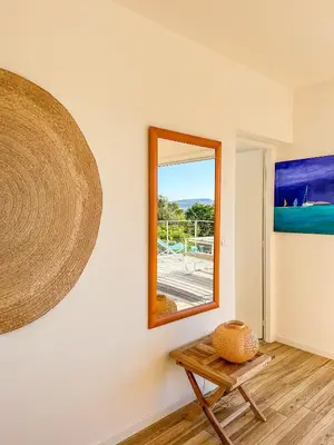 a mirror on a wall next to a table at Casa Luna Di Santa Lucia in Sainte-Lucie de Porto-Vecchio