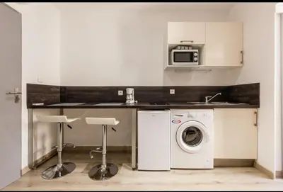 a kitchen with a washing machine and a microwave at joli studio centre ville in Ajaccio