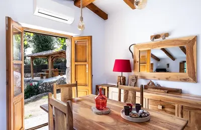 a dining room with a wooden table and a mirror at U Caseddu in Sotta