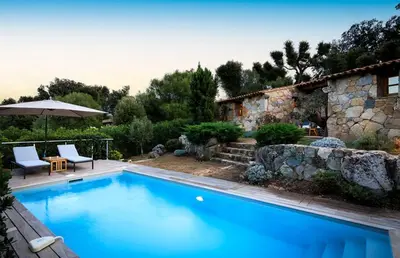 a swimming pool in front of a building with a house at U Caseddu in Sotta