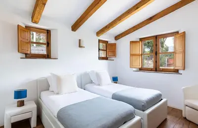 two beds in a room with white walls and windows at U Caseddu in Sotta