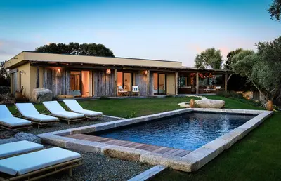 a backyard with a pool with chairs and a house at Villa Grazie in Bonifacio