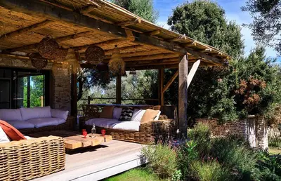 a patio with wicker furniture on a wooden deck at Villa Grazie in Bonifacio
