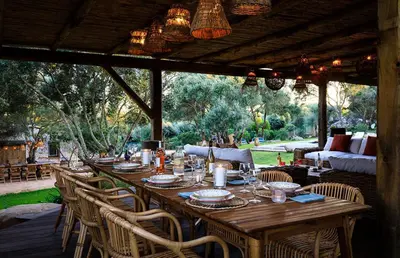 a long wooden table with chairs and a couch at Villa Grazie in Bonifacio