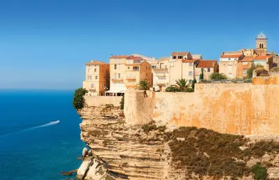 a town on the edge of a cliff next to the ocean at Villa Grazie in Bonifacio