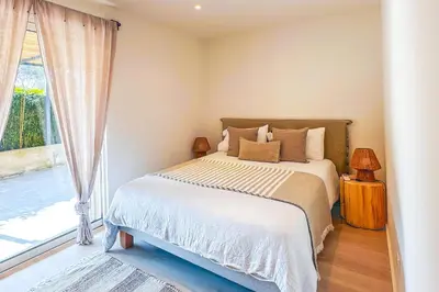 a bedroom with a bed and a large window at Villa Mathilda Di Porto-Vecchio in Lecci