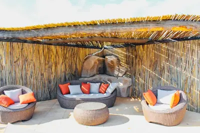 a patio with two wicker chairs and a fireplace at Villa Mathilda Di Porto-Vecchio in Lecci