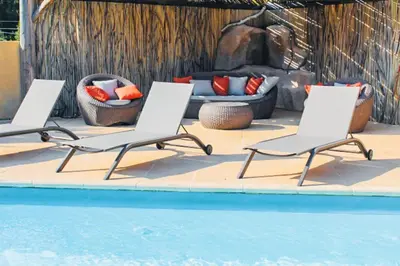 three lounge chairs and a pool with a fireplace at Villa Mathilda Di Porto-Vecchio in Lecci