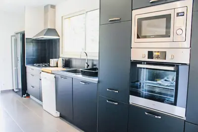a kitchen with blue cabinets and a microwave at Villa Mathilda Di Porto-Vecchio in Lecci