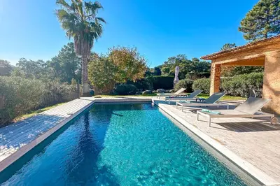 a swimming pool with lounge chairs and a house at Villa Capanaccia Di Arasu in Sainte-Lucie de Porto-Vecchio