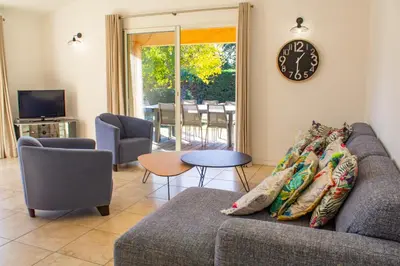 a living room with a couch and a clock on the wall at Villa Capanaccia Di Arasu in Sainte-Lucie de Porto-Vecchio