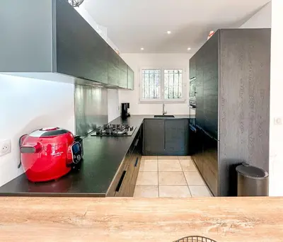 a kitchen with a red appliance on top of a counter at Villa Capanaccia Di Arasu in Sainte-Lucie de Porto-Vecchio