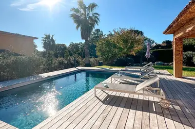 a swimming pool with two lounge chairs on a wooden deck at Villa Capanaccia Di Arasu in Sainte-Lucie de Porto-Vecchio