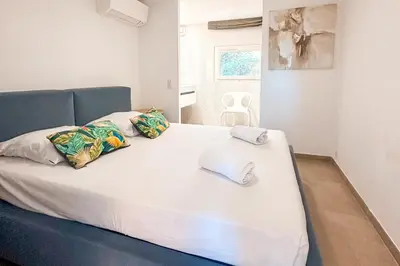 a large white bed with towels on top of it at Villa Capanaccia Di Arasu in Sainte-Lucie de Porto-Vecchio