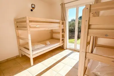 a room with two bunk beds and a window at Villa Capanaccia Di Arasu in Sainte-Lucie de Porto-Vecchio