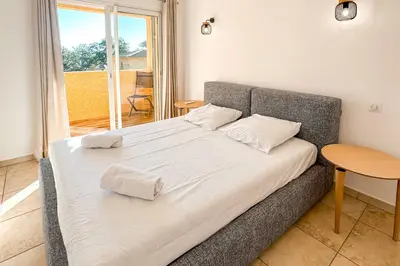 a bed with two pillows on it in a room at Villa Capanaccia Di Arasu in Sainte-Lucie de Porto-Vecchio