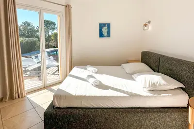 a bed in a room with a large window at Villa Belladona Di Arasu in Sainte-Lucie de Porto-Vecchio