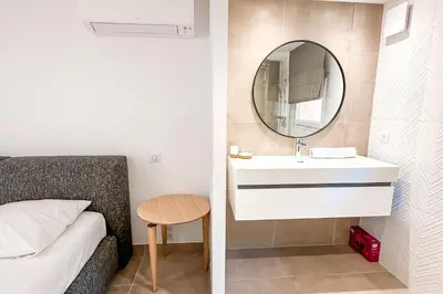 a small bedroom with a sink and a mirror at Villa Belladona Di Arasu in Sainte-Lucie de Porto-Vecchio