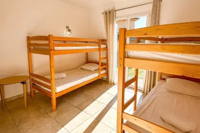 a room with two bunk beds and a table at Villa Belladona Di Arasu in Sainte-Lucie de Porto-Vecchio