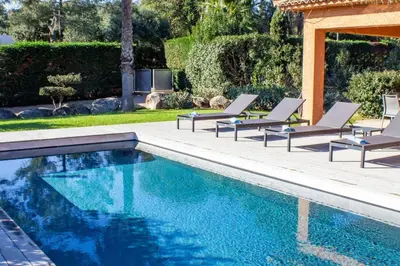 a swimming pool with lounge chairs next to a house at Villa Belladona Di Arasu in Sainte-Lucie de Porto-Vecchio