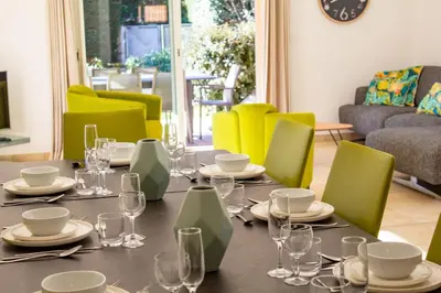 a dining room with a table and green chairs at Villa Belladona Di Arasu in Sainte-Lucie de Porto-Vecchio