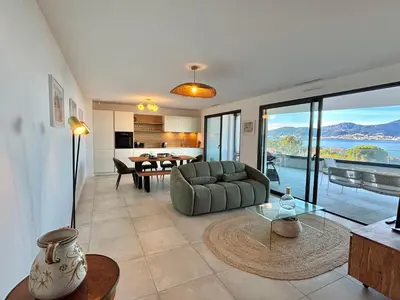 a living room with a couch and a table at Appartement vue mer Royal Palm Porticcio in Porticcio