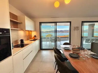 a kitchen and dining room with a table with a view at Appartement vue mer Royal Palm Porticcio in Porticcio